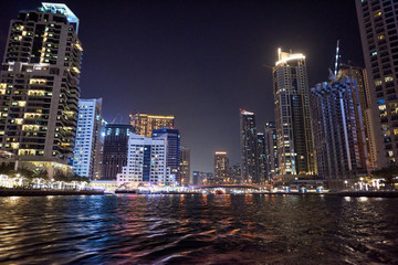 Fototapeta na wymiar Dubai Marina at night with colorful touristic boats