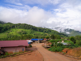Green mountain scenery, fog in the mountains, sky covered with white clouds.