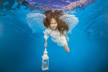 White angel with a flashlight underwater. Underwater girls pictures