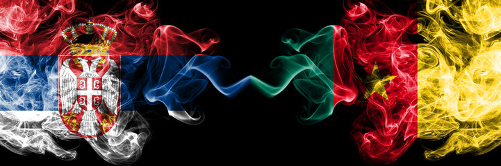 Serbia vs Cameroon, Cameroonian smoky mystic flags placed side by side. Thick colored silky smokes combination of Serbian and Cameroon, Cameroonian flag