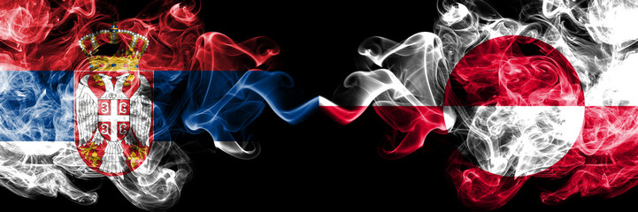 Serbia vs Greenland smoky mystic flags placed side by side. Thick colored silky smokes combination of Serbian and Greenland flag