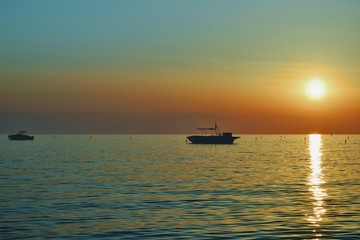 Fototapeta na wymiar Sunset over Adriatic Sea. View from Golem / Durres, Albania. Beautiful sunset with two fishing boat silhouettes