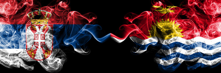 Serbia vs Kiribati smoky mystic flags placed side by side. Thick colored silky smokes combination of Serbian and Kiribati flag