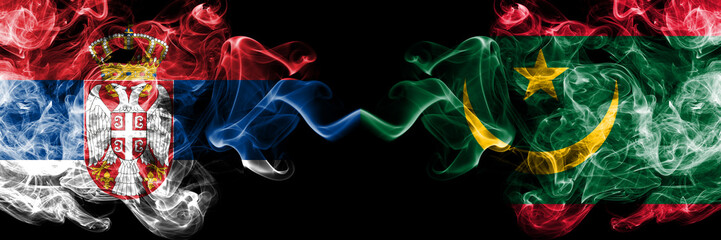 Serbia vs Mauritania, Mauritanian smoky mystic flags placed side by side. Thick colored silky smokes combination of Serbian and Mauritania, Mauritanian flag