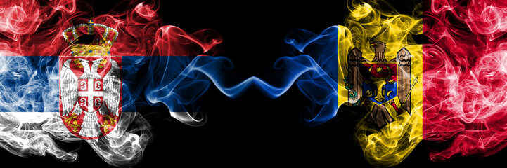 Serbia vs Moldova, Moldovan smoky mystic flags placed side by side. Thick colored silky smokes combination of Serbian and Moldova, Moldovan flag