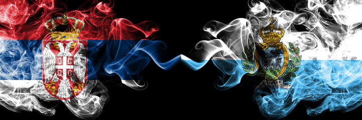 Serbia vs San Marino, Sammarinese smoky mystic flags placed side by side. Thick colored silky smokes combination of Serbian and San Marino, Sammarinese flag