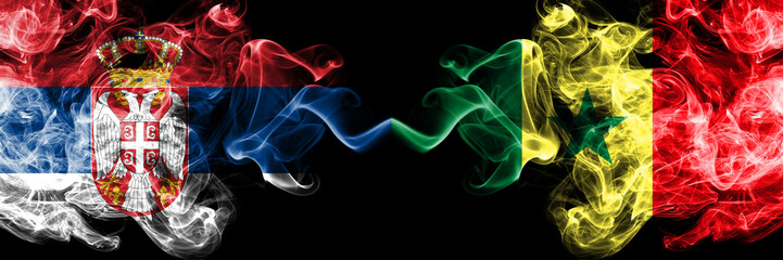 Serbia vs Senegal, Senegalese smoky mystic flags placed side by side. Thick colored silky smokes combination of Serbian and Senegal, Senegalese flag