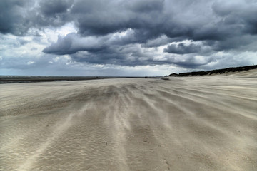 Impressive sand drifts and clouds during a hurricane at the Belgium coast