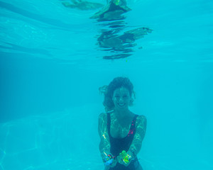 Underwater photograph of blonde girl with curls and red swimsuit.