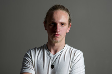 Young caucasian serious adult with blonde hair and blue eyes