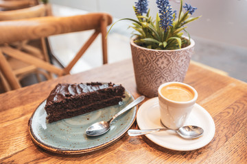Chocholate cake and coffee mug on a table from cafe