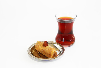 traditional Turkish sweet with baklava nuts and Turkish tea in a glass beaker