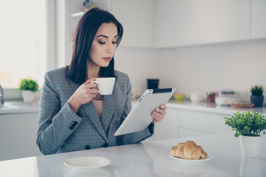 Close up photo beautiful she her corporate lady look e-reader check report hands arms hold hot beverage attentive startup investor formal-wear checkered plaid costume bright white kitchen indoors