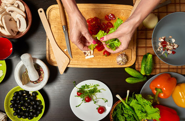 Close-up overhead shot of woman hands preparing a healthy salad