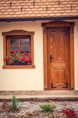 Fototapeta na wymiar brown wooden window with flowers and wooden doors,.