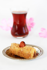 traditional Turkish sweet with baklava nuts and Turkish tea in a glass beaker