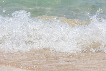 Macro shot of some sea waves hitting the beach