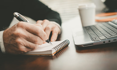 Hands taking notes on notebook