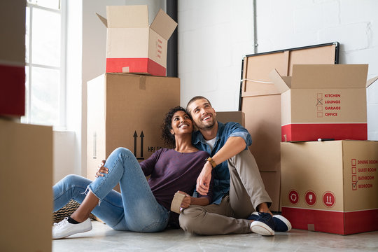 Multiethnic couple in new home with boxes