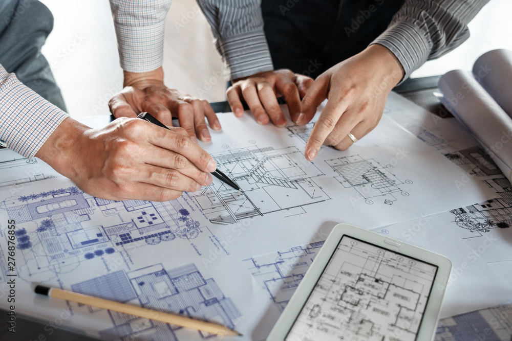 Poster real-estate concept, two engineer and architect discussing blueprints data working and digital table