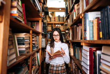 people, knowledge, education and school concept - student girl or young woman reading a book in the...