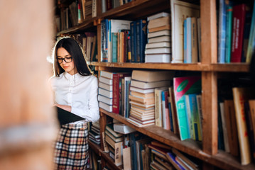 people, knowledge, education and school concept - student girl or young woman reading a book in the old library