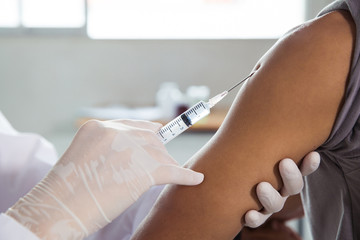 Close-up of hands injecting  male patients arm .Doctor giving a patient injection.