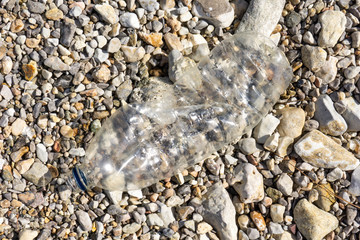 Garbage on a stony beach. Foil and plastic on the stones. Do not litter, save the planet,
