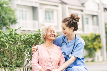 Caregiver with Asian elderly woman outdoor