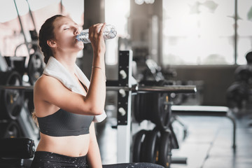 woman drinking water from bottle after workout