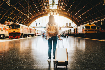 woman traveler standing with luggage at train station. © interstid