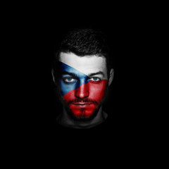 Flag of Czech Republic painted on a face of a man on black background.