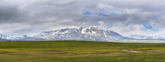 Montenegro, XXL nature landscape panorama of snow covered peaks and high mountains in spectacular untouched durmitor national park behind endless green pastures near zabljak