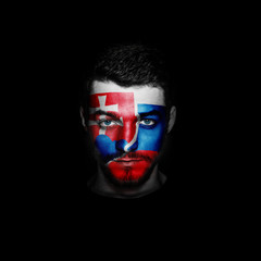 Flag of Slovakia painted on a face of a man on black background.