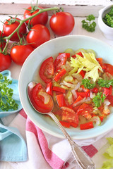 Summer vitamin detox soup with celery, red bell pepper and tomatoes, parsley garnish