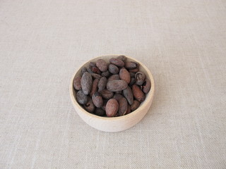 Fototapeta na wymiar Roasted cocoa beans in a wooden bowl