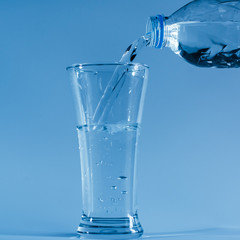 Pour water from the bottle into the glass