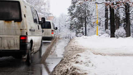 The car b stro drives through a puddle of dirt, sprays fly from under the wheels