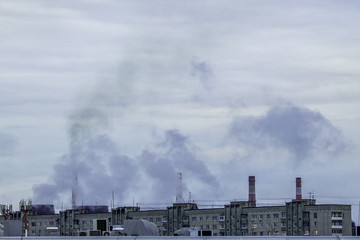 Fototapeta premium industrial chimneys on cloudy sky background with heavy smoke causing air pollution as environmental problem