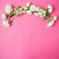 Floral frame with white flowers on pink background. Flat lay, top view.