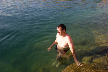 Fototapeta premium Male young swimmer on the water - summer sea