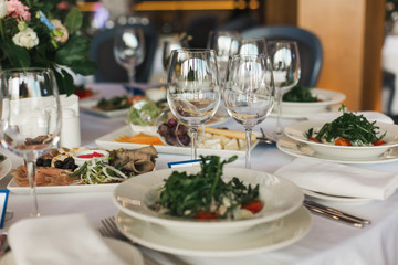 of the dishes and food on the served table.  long served feast table.festive table in the restaurant.Interior of the banquet hall in the cafe.banquet table in the restaurant.place of celebration