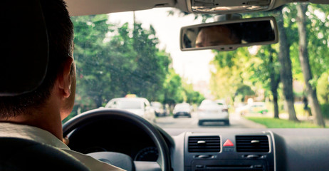 Man driving car from rear view on the city
