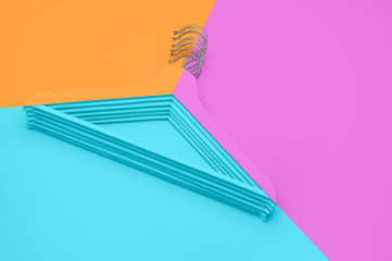 Creative fashion concept. Flat lay top view colored wooden hangers on blue pink orange neon background minimalism style pop-art. Sale discount store shopping concept design empty hanger feminine blog