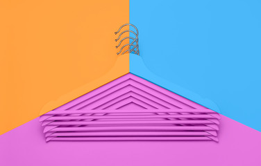 Creative fashion concept. Flat lay top view colored wooden hangers on blue pink orange neon background minimalism style pop-art. Sale discount store shopping concept design empty hanger feminine blog