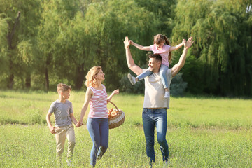 Obraz premium Happy family walking in park on summer day