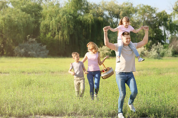 Obraz premium Happy family walking in park on summer day
