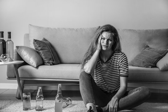 Young Woman With Addiction To Alcohol Relaxing At Home