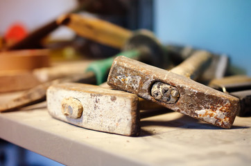 Old destroyed hammers among other hand tools