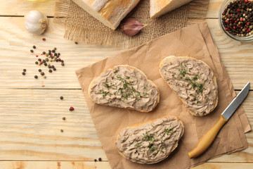 Fresh homemade chicken liver pate with herbs for bread on a natural wooden table. A sandwich. top view